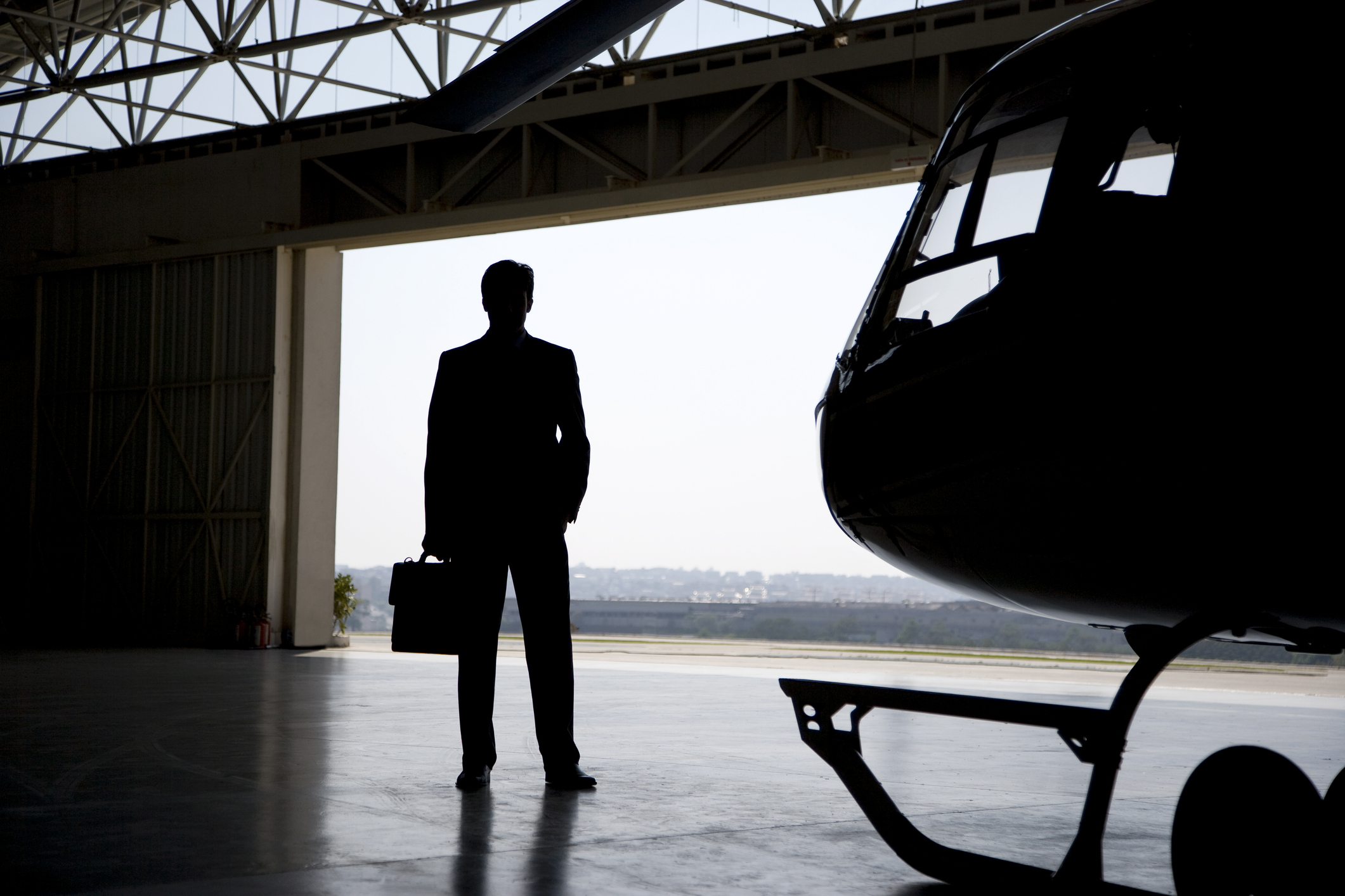 Silhouette Of Business Man In Front Of Helicopter, Hangar